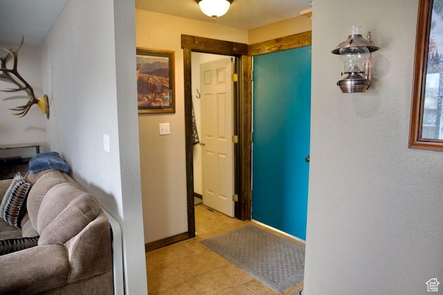 corridor with light tile patterned floors and baseboards