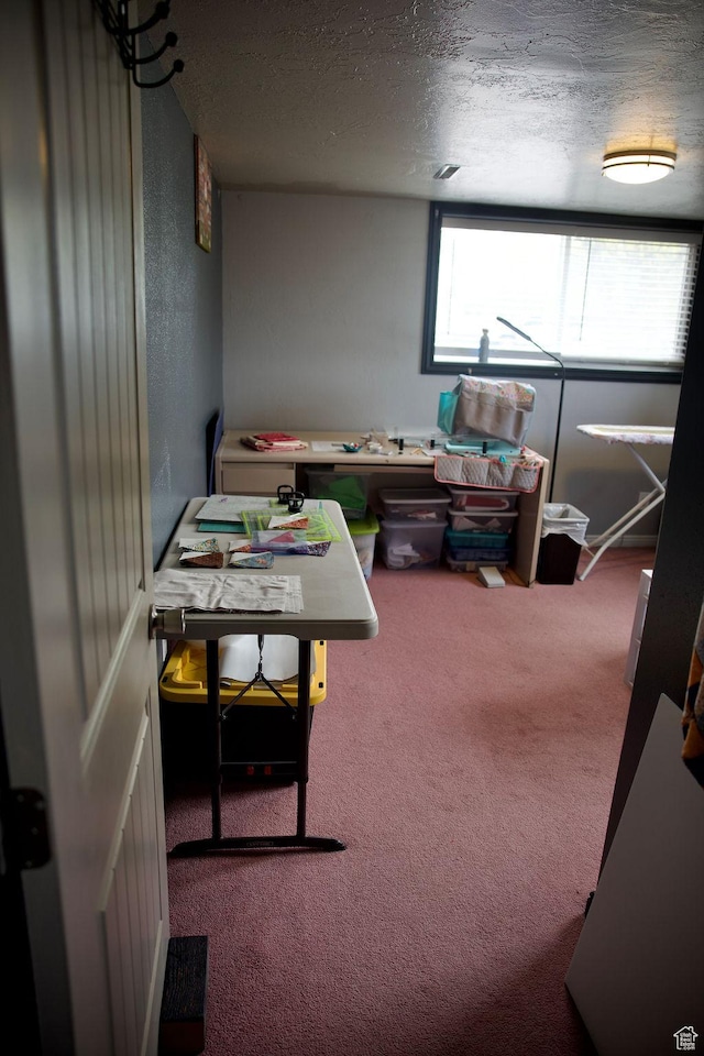 carpeted office space with a textured ceiling