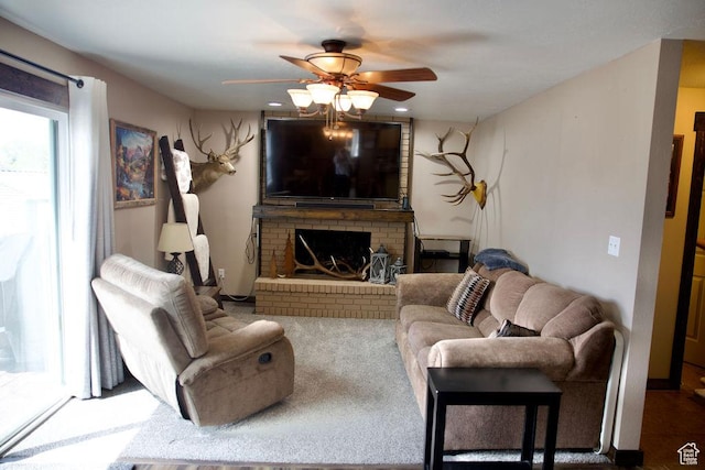 living area with ceiling fan and a fireplace