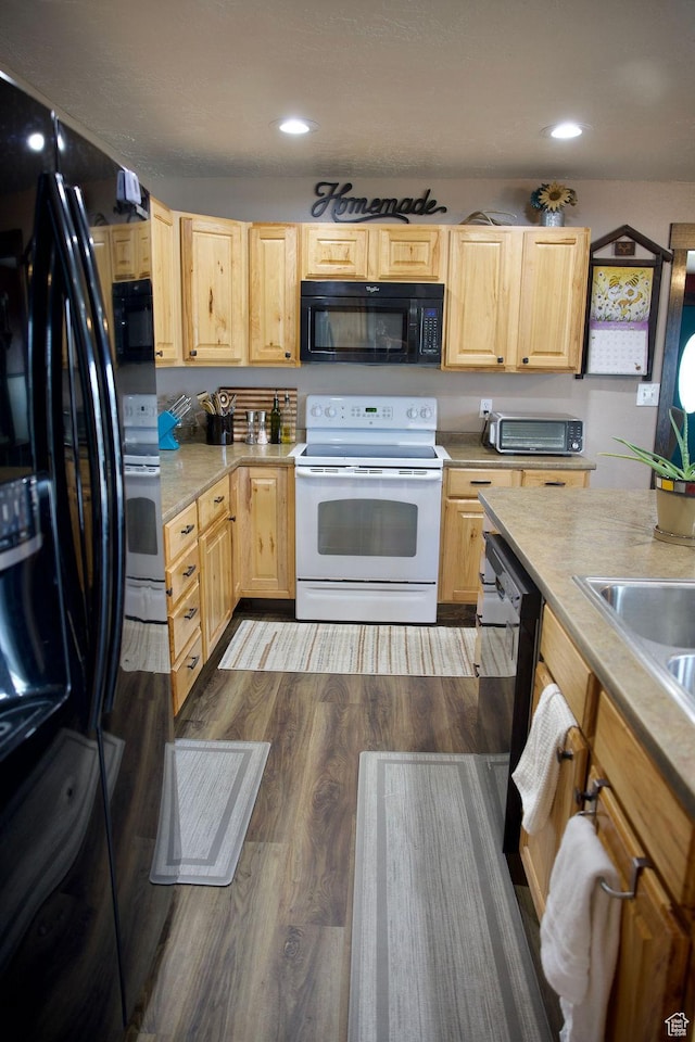 kitchen featuring light countertops, light brown cabinets, black appliances, and dark wood-style flooring