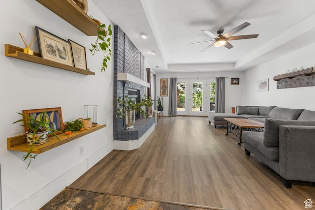 531 E Valley Dr, Heber City, UT 84032 - living room featuring a ceiling fan, wood finished floors, a tray ceiling, and a fireplace