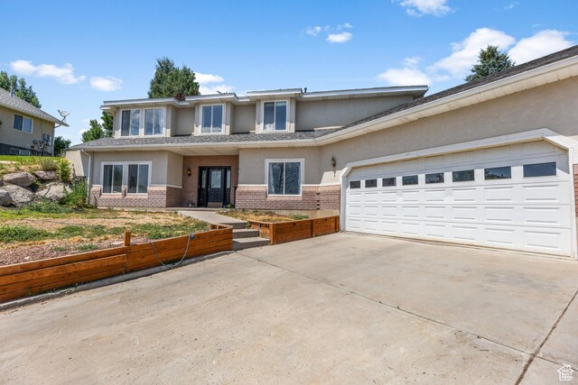 531 E Valley Dr, Heber City, UT 84032 - view of front facade with a garage, stucco siding, concrete driveway, and brick siding