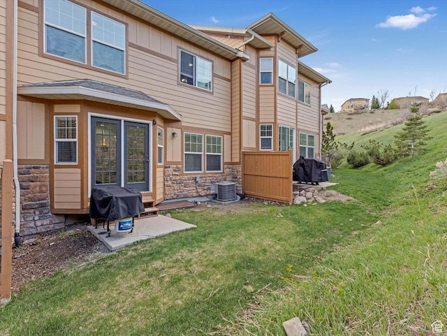 14768 S Deer Park Ln E, Draper Ut Cnty, UT 84020 - rear view of property with a lawn, a patio, board and batten siding, and stone siding