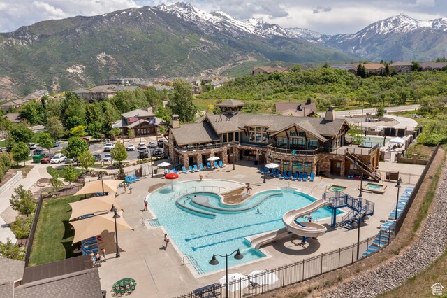 14768 S Deer Park Ln E, Draper Ut Cnty, UT 84020 - community pool with fence, a water slide, a mountain view, and a patio area