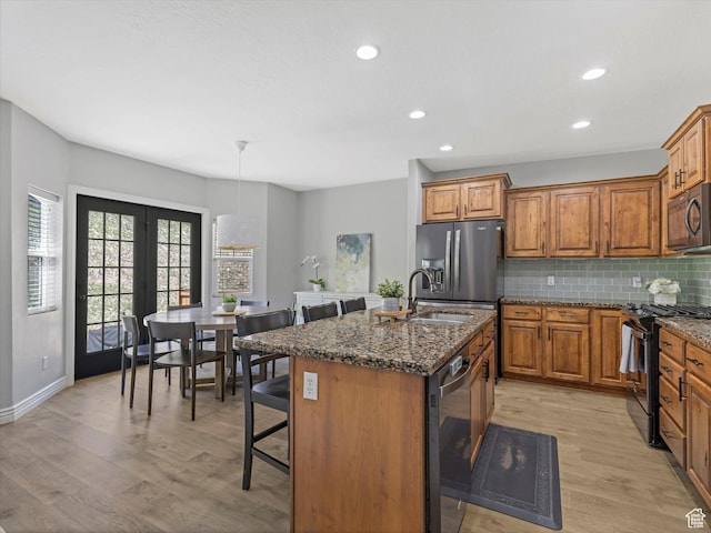 14768 S Deer Park Ln E, Draper Ut Cnty, UT 84020 - kitchen with a breakfast bar area, brown cabinets, a sink, light wood-style floors, and stainless steel appliances