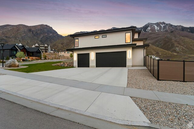 3944 W Oak Hill Dr, Alpine, UT 84004 - contemporary house featuring an attached garage, a mountain view, fence, and concrete driveway