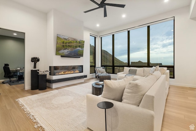 3944 W Oak Hill Dr, Alpine, UT 84004 - living area featuring a ceiling fan, baseboards, a glass covered fireplace, recessed lighting, and light wood-style flooring