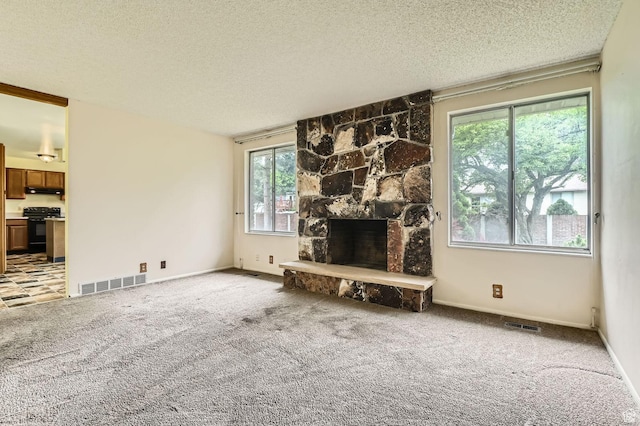 4758 S Mocha Dr W, Taylorsville, UT 84129 - living room featuring a stone fireplace, light colored carpet, a textured ceiling, and visible vents