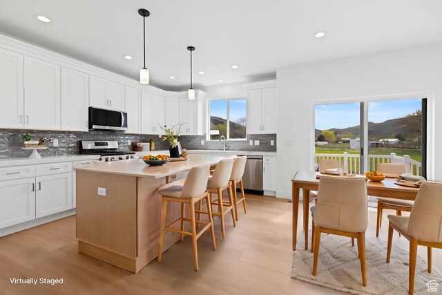 544 N 350 W Unit 7R, Morgan, UT 84050 - kitchen featuring appliances with stainless steel finishes, backsplash, light wood-style flooring, white cabinets, and recessed lighting