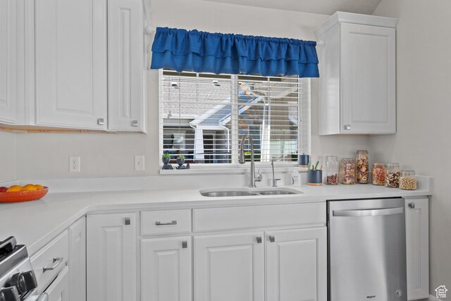 kitchen with a sink, light countertops, white cabinets, and stainless steel dishwasher