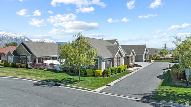 exterior space featuring a residential view, a mountain view, and a front yard