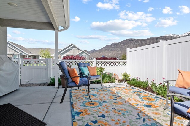 view of patio / terrace featuring a gate, a mountain view, and a fenced backyard
