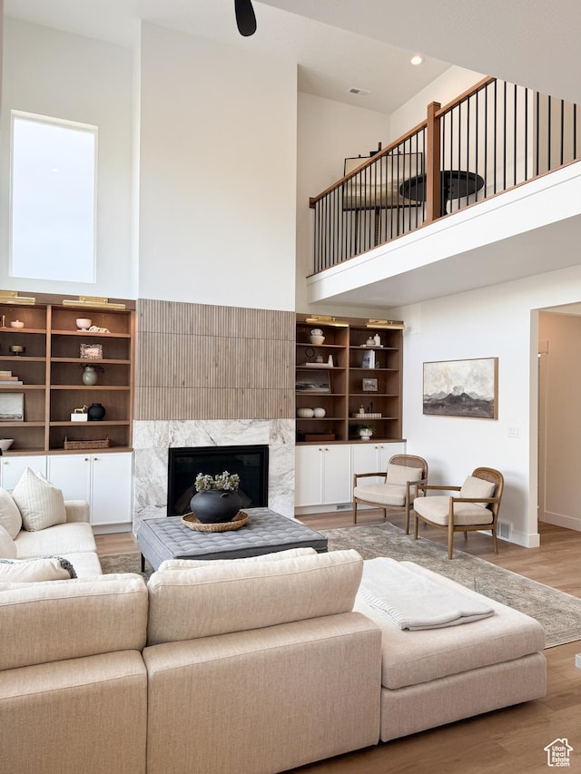 7648 S Iron Cyn Unit 341, West Jordan, UT 84081 - living area with a towering ceiling, a high end fireplace, wood finished floors, baseboards, and recessed lighting