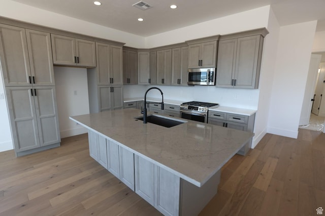 3842 S Kennedy Ln Unit 124, Washington, UT 84780 - kitchen with visible vents, appliances with stainless steel finishes, a sink, baseboards, and light wood finished floors
