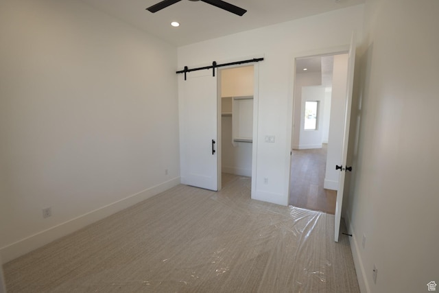 3842 S Kennedy Ln Unit 124, Washington, UT 84780 - unfurnished bedroom featuring a barn door, light carpet, recessed lighting, baseboards, and a spacious closet