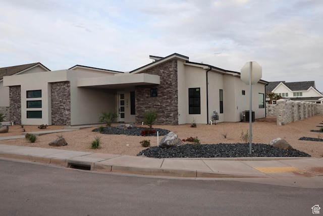 3842 S Kennedy Ln Unit 124, Washington, UT 84780 - view of front of home featuring central AC unit, stucco siding, and stone siding