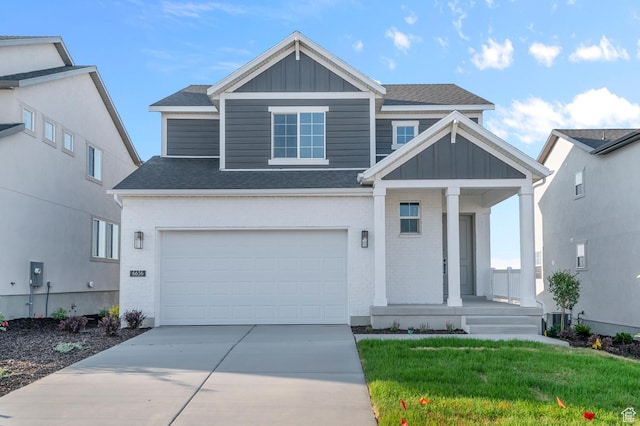 6636 W Spring Snow Ln, Herriman, UT 84096 - view of front of house featuring board and batten siding, covered porch, roof with shingles, driveway, and an attached garage