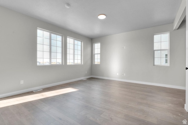6636 W Spring Snow Ln, Herriman, UT 84096 - spare room with wood finished floors, a smoke detector, and a textured ceiling