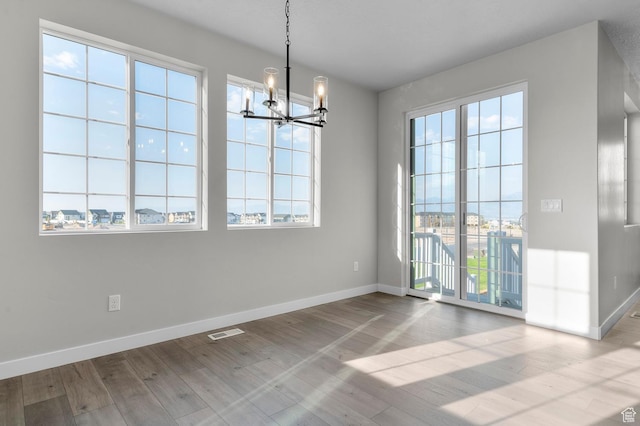 6636 W Spring Snow Ln, Herriman, UT 84096 - unfurnished dining area featuring a chandelier and wood finished floors