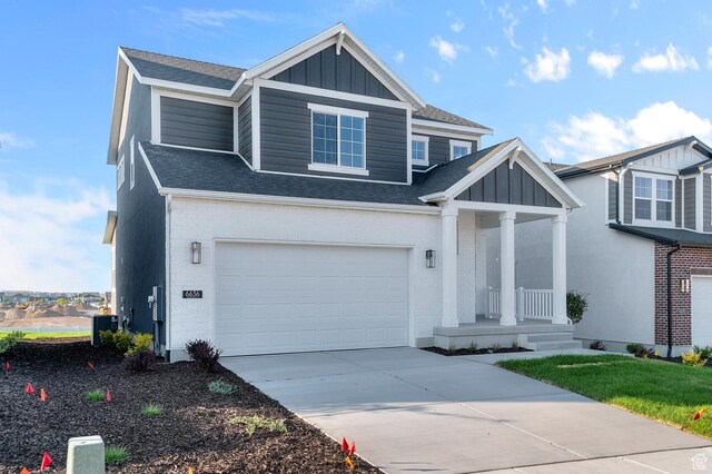 6636 W Spring Snow Ln, Herriman, UT 84096 - craftsman-style house with board and batten siding, covered porch, concrete driveway, roof with shingles, and an attached garage