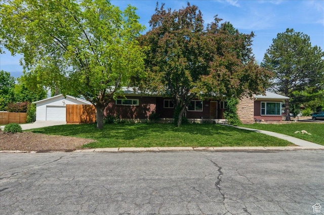 view of front of home featuring concrete driveway, a front yard, and a garage