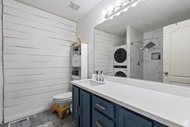 2099 E Hickock Way, Eagle Mountain, UT 84005 - full bathroom featuring stacked washer and clothes dryer, tiled shower, toilet, vanity, and wooden walls