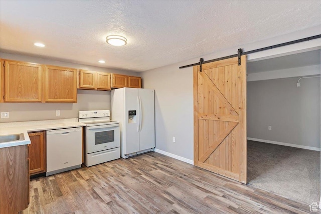 8522 S Kolby Ln, Midvale, UT 84047 - kitchen featuring white appliances, a barn door, light countertops, light wood-type flooring, and a textured ceiling