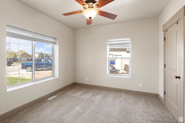 empty room featuring baseboards, light colored carpet, and a healthy amount of sunlight