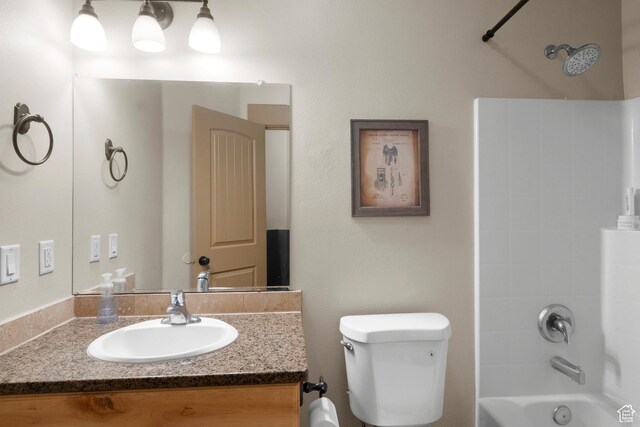 bathroom with vanity, toilet, and  shower combination