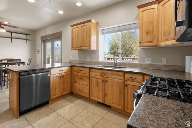 kitchen featuring ceiling fan, a sink, stainless steel microwave, a peninsula, and dishwashing machine