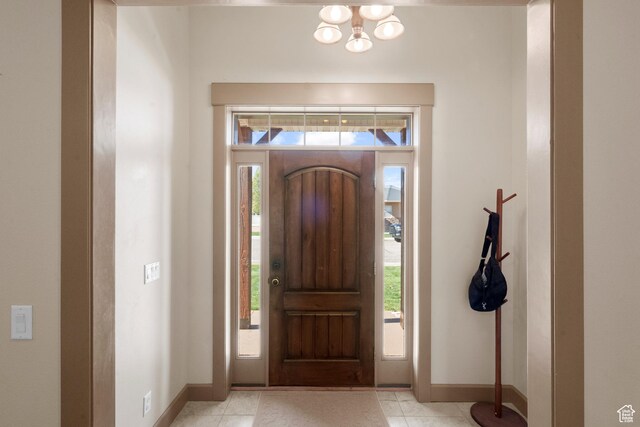 foyer featuring baseboards and a chandelier