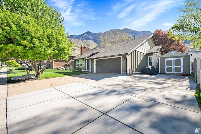 2974 N 1375 E, North Ogden, UT 84414 - ranch-style home with a garage, board and batten siding, a shed, a mountain view, and driveway