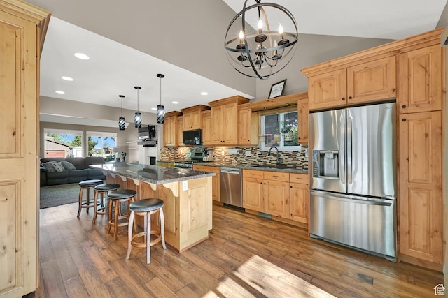 2974 N 1375 E, North Ogden, UT 84414 - kitchen featuring a notable chandelier, a breakfast bar area, stainless steel appliances, decorative backsplash, and wood finished floors