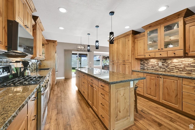 2974 N 1375 E, North Ogden, UT 84414 - kitchen featuring decorative backsplash, glass insert cabinets, a center island, light wood-style flooring, and gas stove