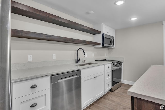 1138 N 1000 E, Mapleton, UT 84664 - kitchen with stainless steel appliances, open shelves, a sink, white cabinetry, and light wood-type flooring
