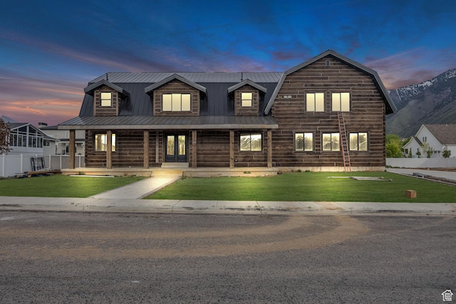 cabin featuring a porch, metal roof, a lawn, log siding, and fence