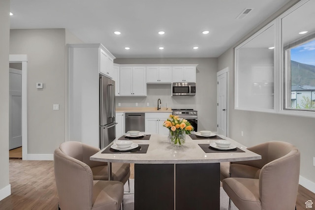1138 N 1000 E, Mapleton, UT 84664 - kitchen featuring stainless steel appliances, baseboards, a breakfast bar area, light wood-style flooring, and recessed lighting