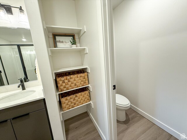 3656 S 4600 W Unit 220, West Haven, UT 84401 - bathroom featuring vanity, a shower with door, wood finished floors, toilet, and baseboards