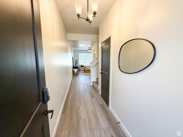 3656 S 4600 W Unit 220, West Haven, UT 84401 - hallway featuring light wood-style floors, baseboards, and an inviting chandelier