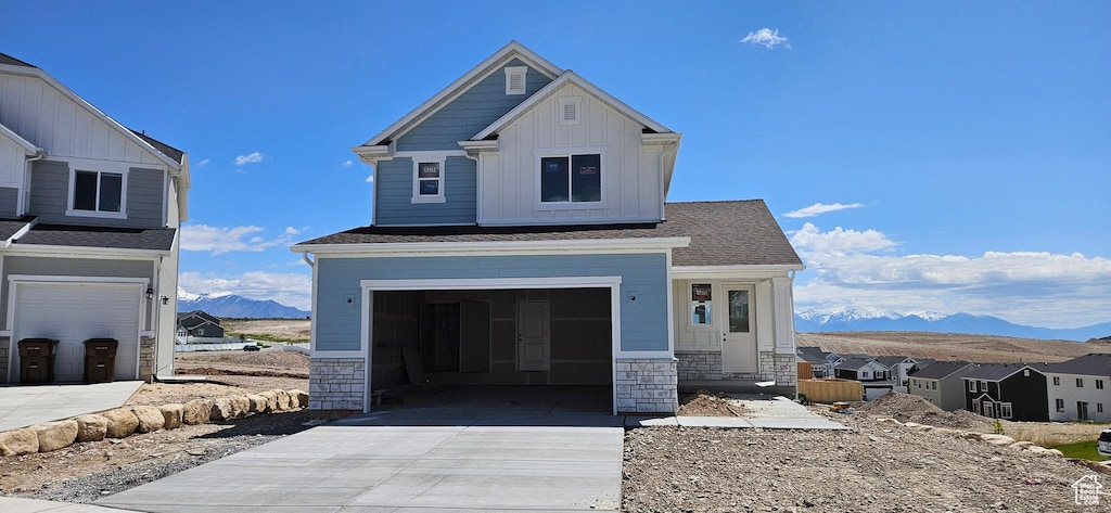 9814 N Bridge, Eagle Mountain, UT 84005 - craftsman house featuring a mountain view, concrete driveway, board and batten siding, stone siding, and an attached garage
