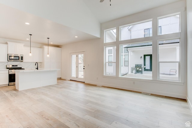 628 W Murray Ln Unit 155, Murray, UT 84123 - unfurnished living room featuring a sink, baseboards, light wood finished floors, and visible vents