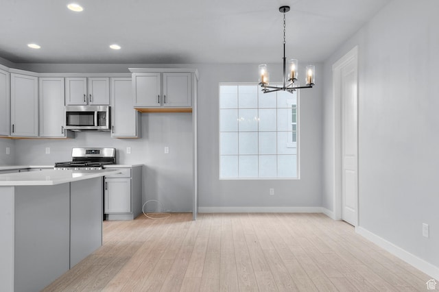 6641 W Spring Snow Ln, Herriman, UT 84096 - kitchen featuring appliances with stainless steel finishes, a chandelier, light wood finished floors, light countertops, and recessed lighting