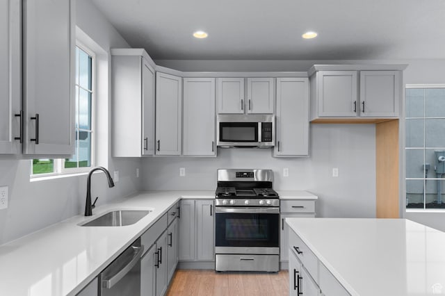 6641 W Spring Snow Ln, Herriman, UT 84096 - kitchen with stainless steel appliances, a sink, light countertops, recessed lighting, and light wood-style flooring
