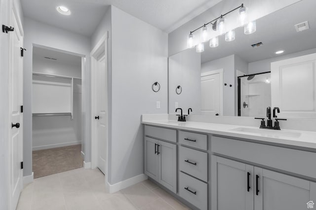 6641 W Spring Snow Ln, Herriman, UT 84096 - full bath featuring a stall shower, baseboards, double vanity, tile patterned flooring, and a spacious closet