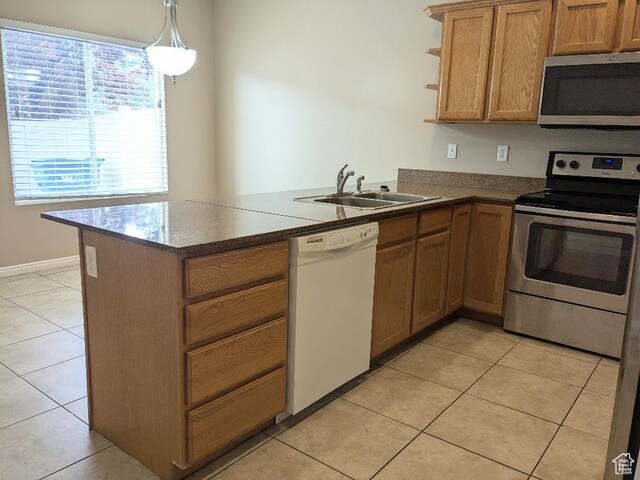 kitchen featuring a sink, appliances with stainless steel finishes, light tile patterned floors, and a peninsula