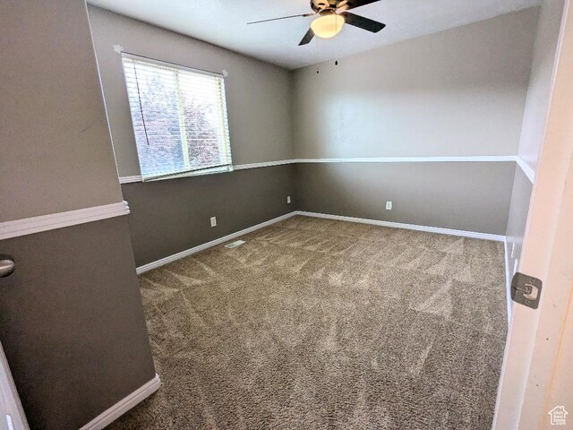 spare room with baseboards, a ceiling fan, carpet flooring, and visible vents