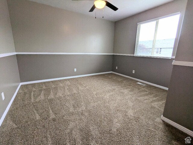 unfurnished room with baseboards, carpet flooring, ceiling fan, and visible vents