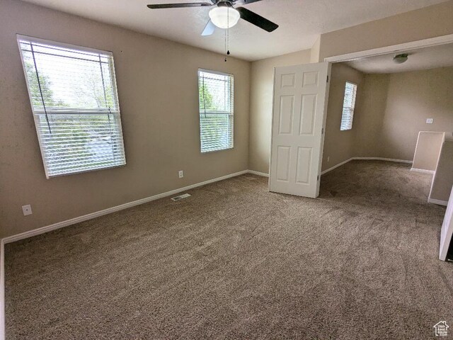 interior space with baseboards, ceiling fan, visible vents, and a healthy amount of sunlight