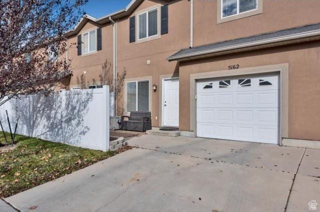 view of front facade featuring an attached garage, driveway, and stucco siding