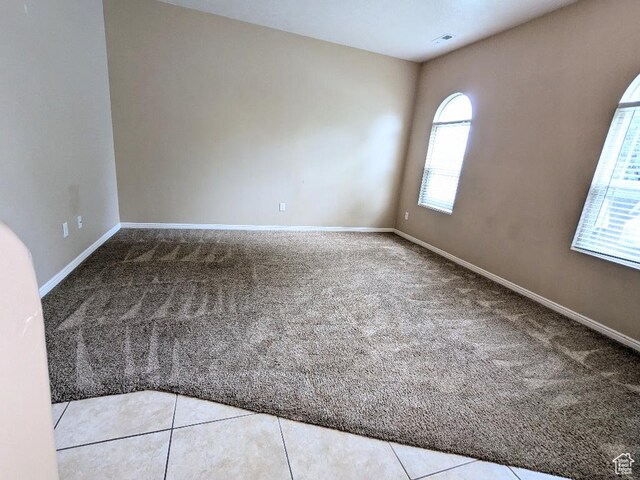 unfurnished room with baseboards and carpet flooring